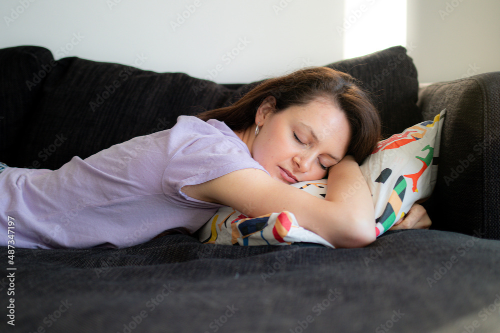 Daydreaming of a young woman during the day on a sofa