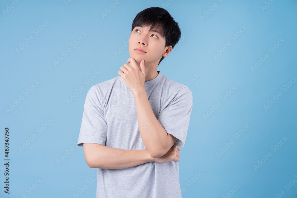 Young Asian man posing on blue background Young Asian man posing on blue background