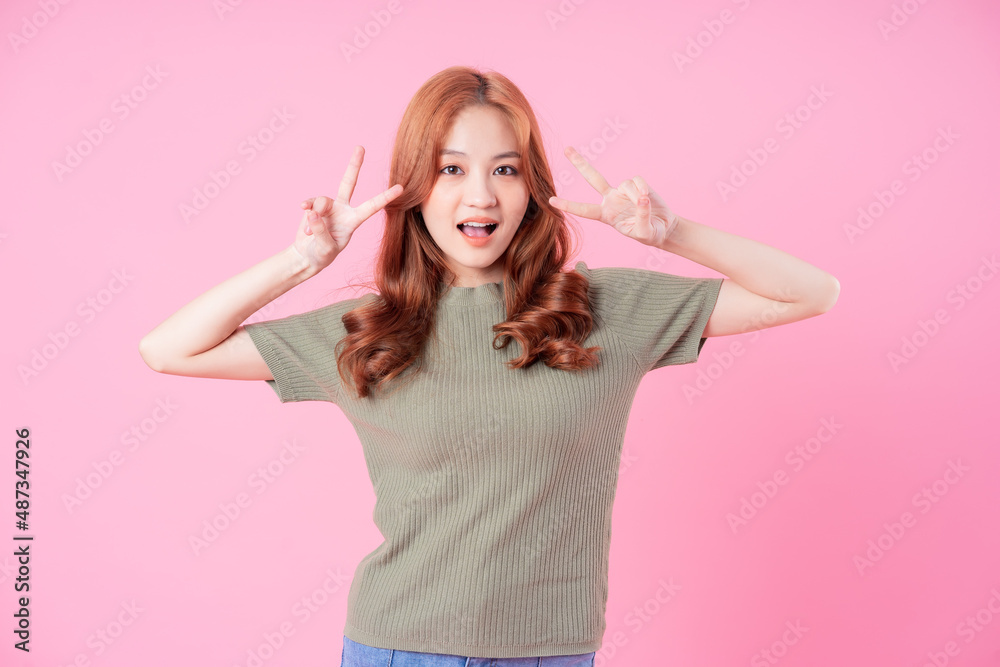 Young Asian woman posing on pink background Young Asian woman posing on pink background