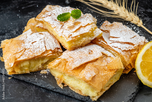 Bugatsa pastries made from filo puff pastry and custard sprinkled with powder. photo