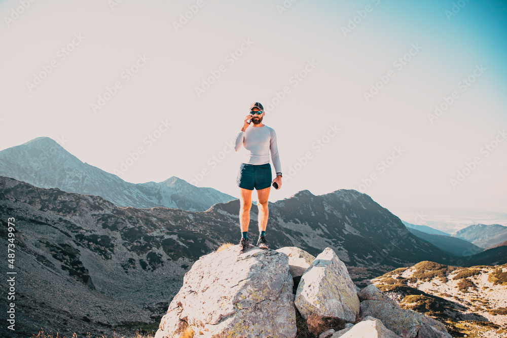 man using mobile phone on mountain top