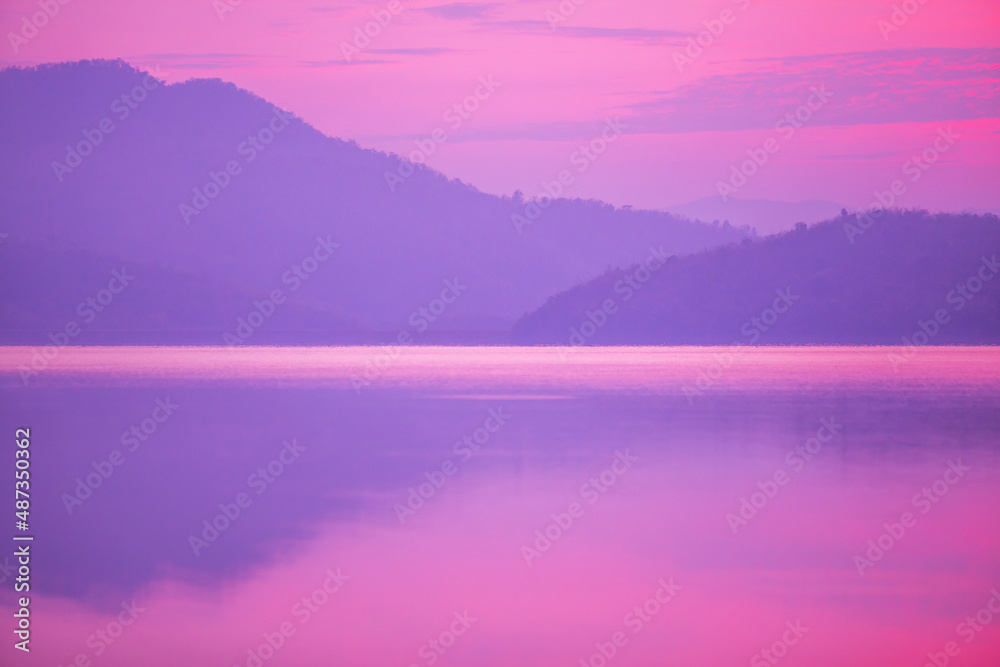 Sunrise time at lake or river with mountain on the background. in pink color tone.