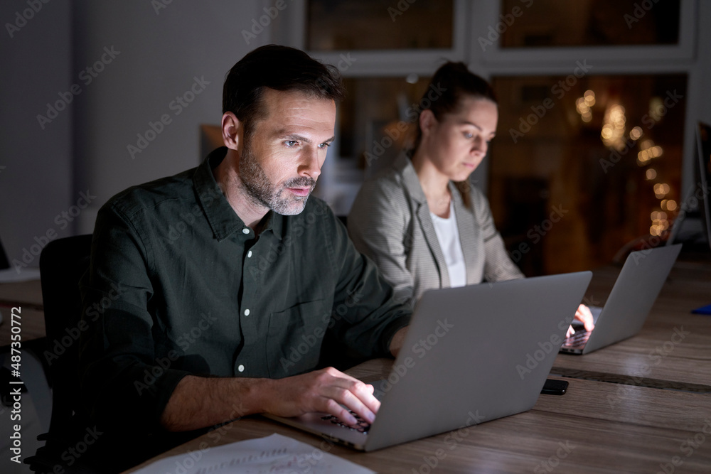 Obraz premium Caucasian workers working late at the office