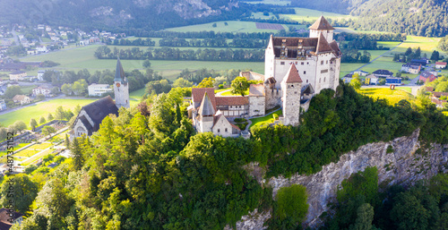 View from drone of stone Gutenberg Castle on top of green hill on background with small town of Balzers, Liechtenstein photo