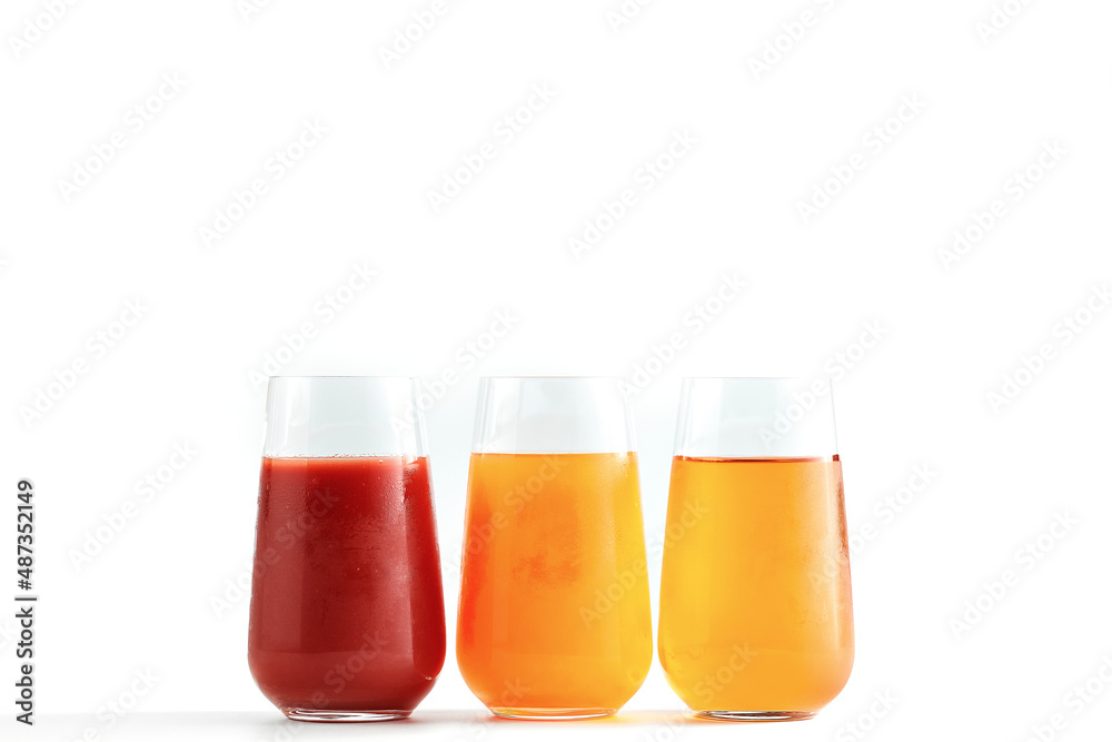 Three freshly squeezed juices: orange, grapefruit and apple in glasses isolated on a white background