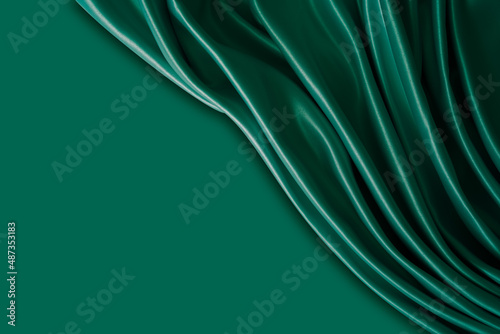 Beautiful elegant wavy dark green satin silk luxury cloth fabric with monochrome background design. Wallpaper, banner. Copy space.