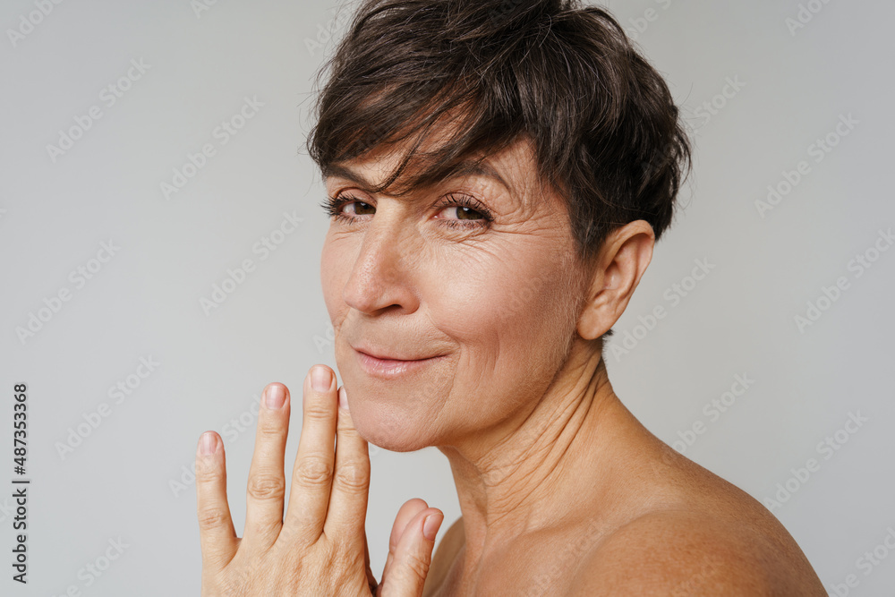 Mature half-naked woman smiling and looking at camera Mature half-naked woman smiling and looking at camera