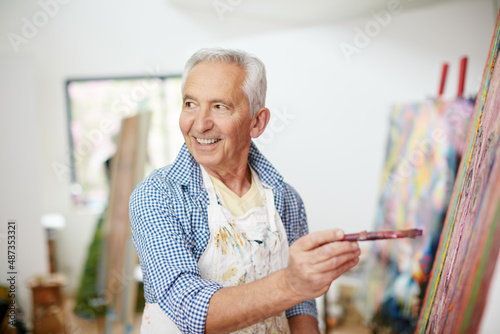 To be an artist is to believe in life. Shot of a senior man working on a painting at home.