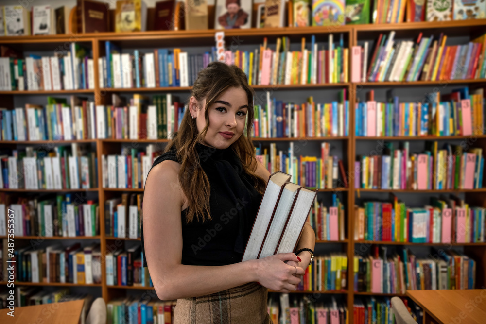 a young smart student is studying useful and interesting in a beautiful old library. a young smart student is studying useful and interesting in a beautiful old library.