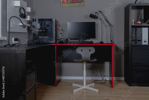 Obraz na płótnie Workplace of a teenage boy with a black and red desk, computer and chair w salonie