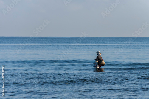 Man walking on the sea holding fishing net