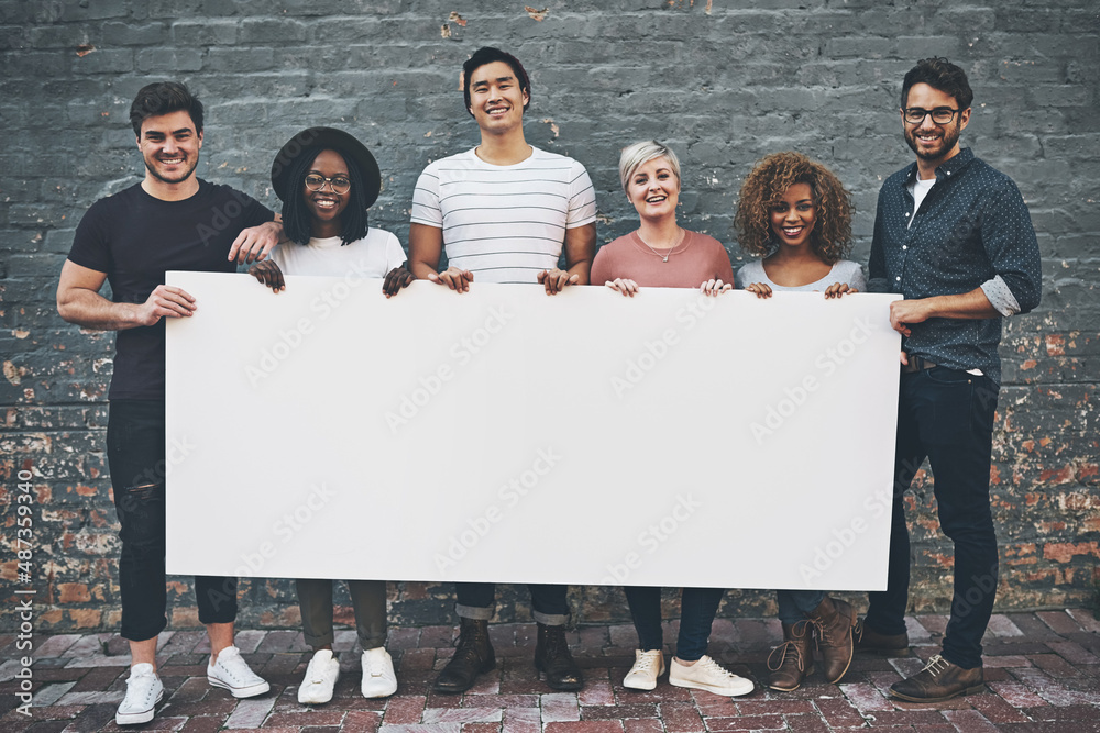 © Camerene Pendl/peopleimages.com - Place your words here and let it be seen. Shot of a diverse group of people holding up a placard outside.