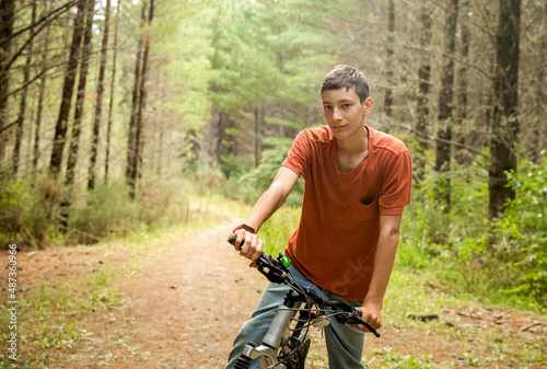 happy teen boy riding a bike on natural background, forest or park. healthy lifestyle, family day out. High quality photo