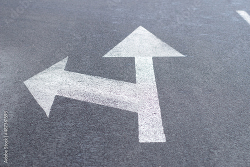 Arrows of road markings on an asphalt road for the direction of movement straight or to the left