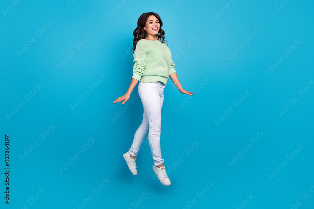 Full length photo of nice young brunette lady go wear shirt pants sneakers isolated on blue background Full length photo of nice young brunette lady go wear shirt pants sneakers isolated on blue background