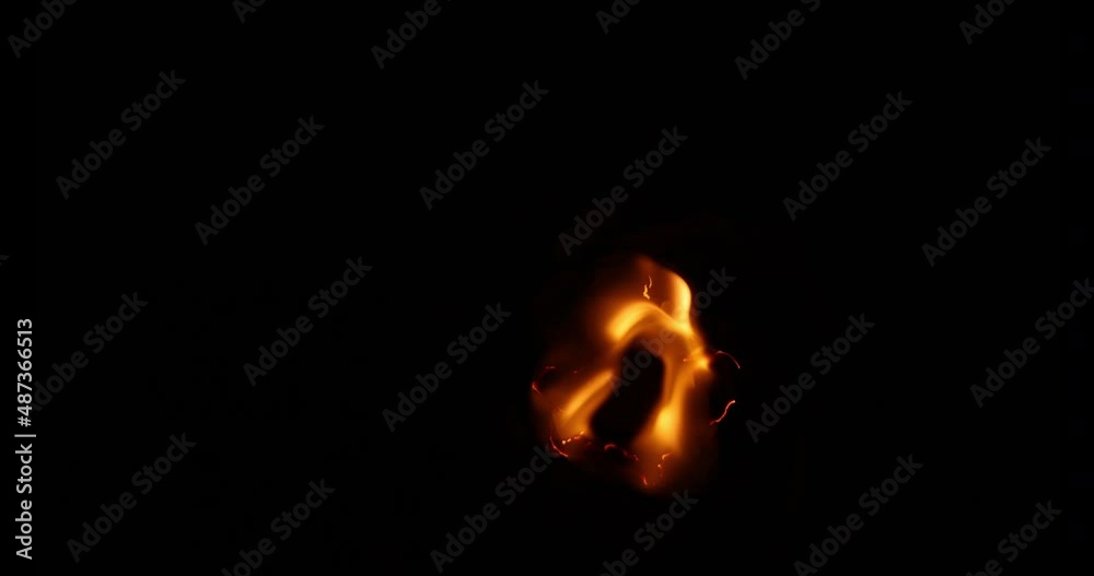 Flames of fire burned a hole in black paper on a black background.