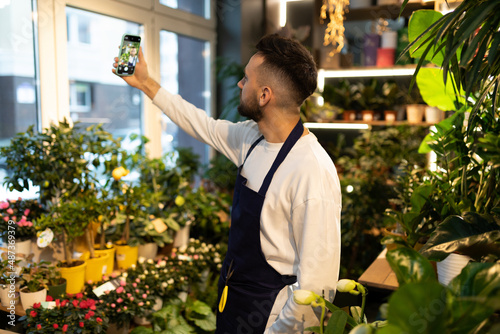 the owner of the garden center will take a selfie surrounded by potted plants