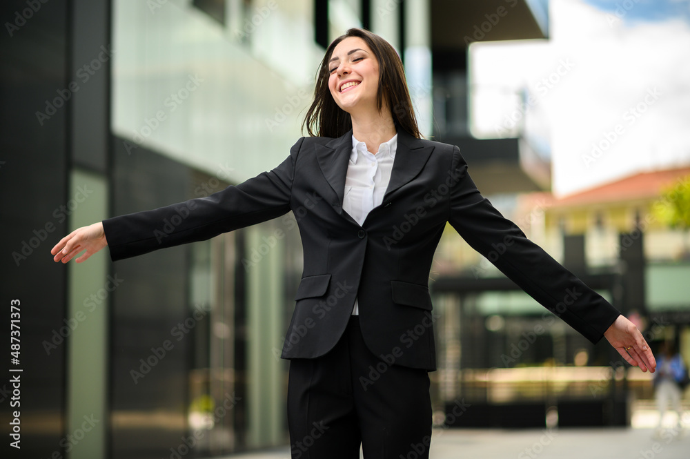 Happy female manager with open arms in sign of freedom and success Happy female manager with open arms in sign of freedom and success