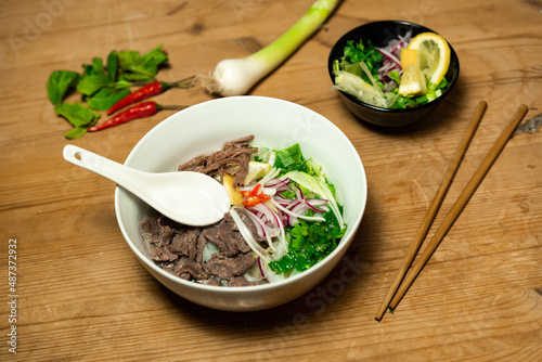 Pho Bo - Vietnamese fresh rice noodle soup with beef, herbs and chili. Vietnam's national dish.
