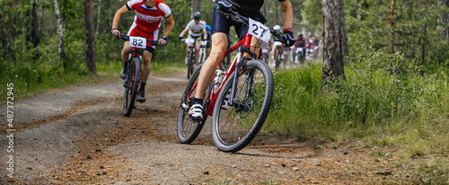 Fotografija athlete leader ahead of large group of mountain bikers