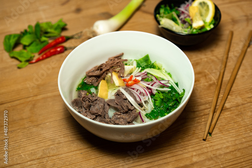 Pho Bo - Vietnamese fresh rice noodle soup with beef, herbs and chili. Vietnam's national dish.
