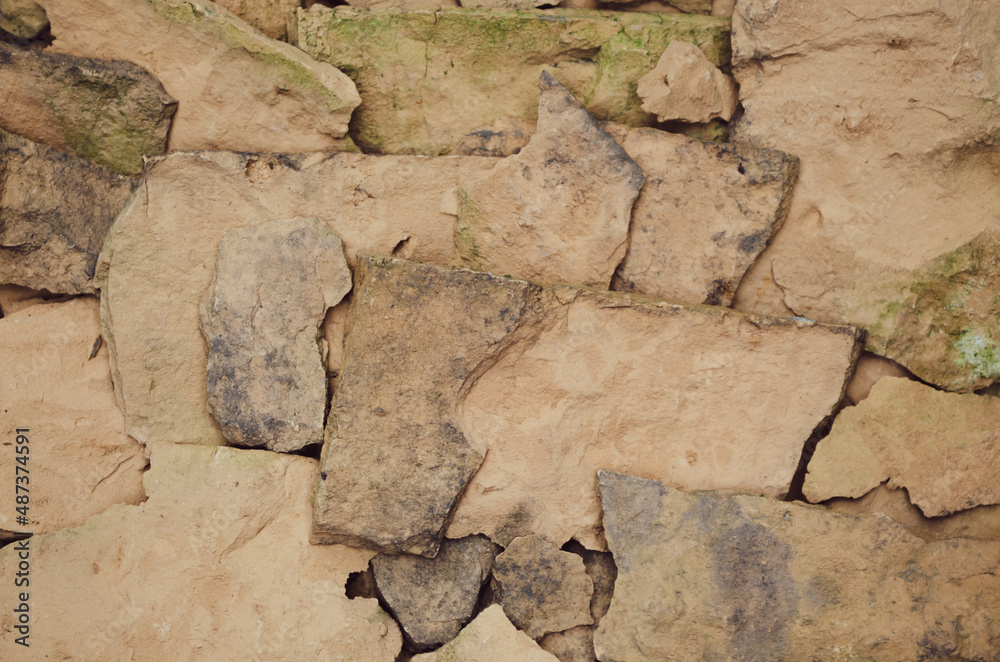 Fototapeta premium wall of broken old red brick with green moss around the edges wallpaper