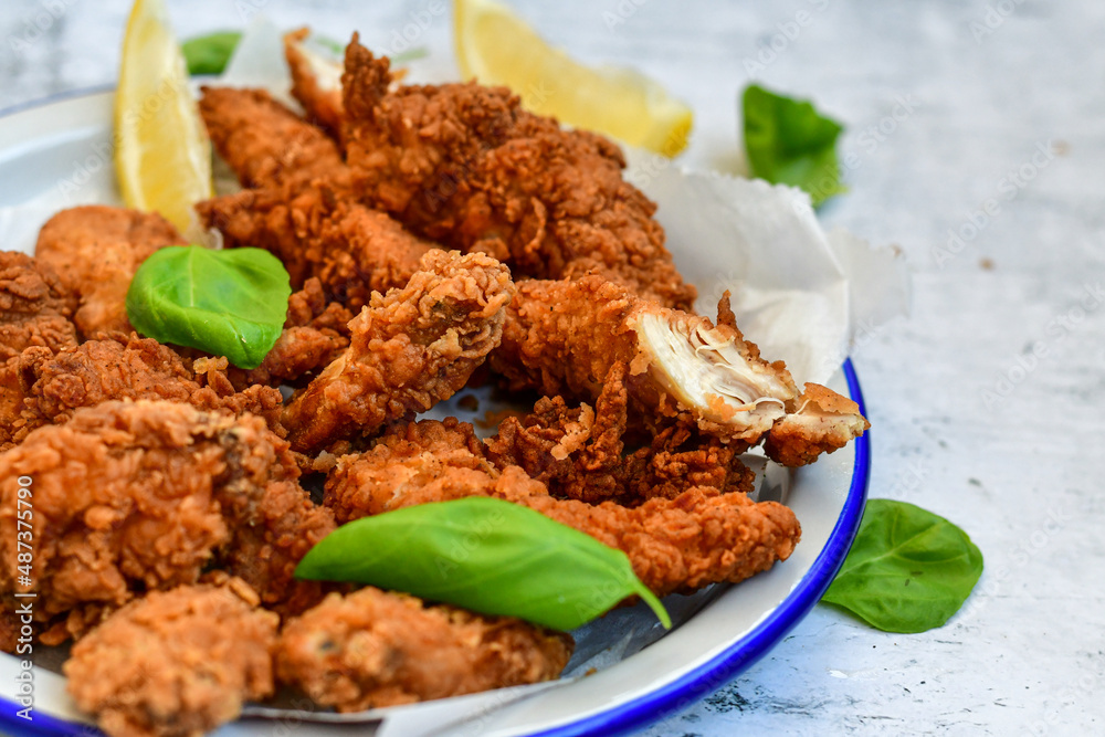 Crispy deep fried chicken strips and wedges potato. Breaded with cornflakes chicken breast fillets with chilly peppers and fresh basil on wooden rustic background
Crispy deep fried chicken strips and wedges potato. Breaded with cornflakes chicken breast fillets with chilly peppers and fresh basil on wooden rustic background