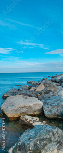 Vertical view of big stones in the sea above blue sky. Coast of the Black Sea in Batumi. 