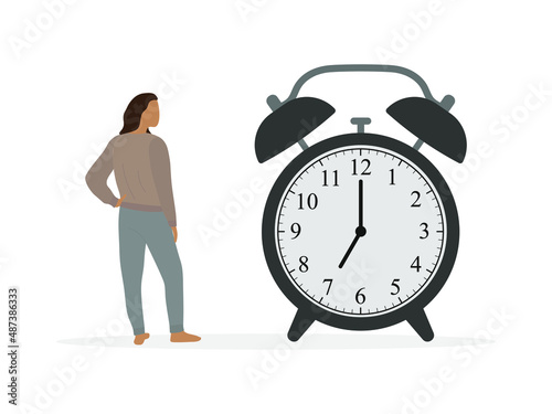 Female character in home clothes looks at a huge alarm clock on a white background