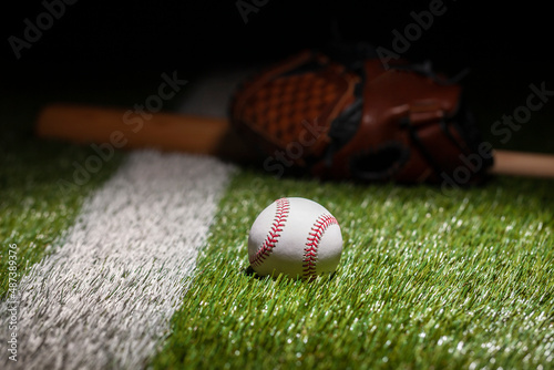 Photography Low angle view of baseball on grass field with stripe and defocused mitt and bat