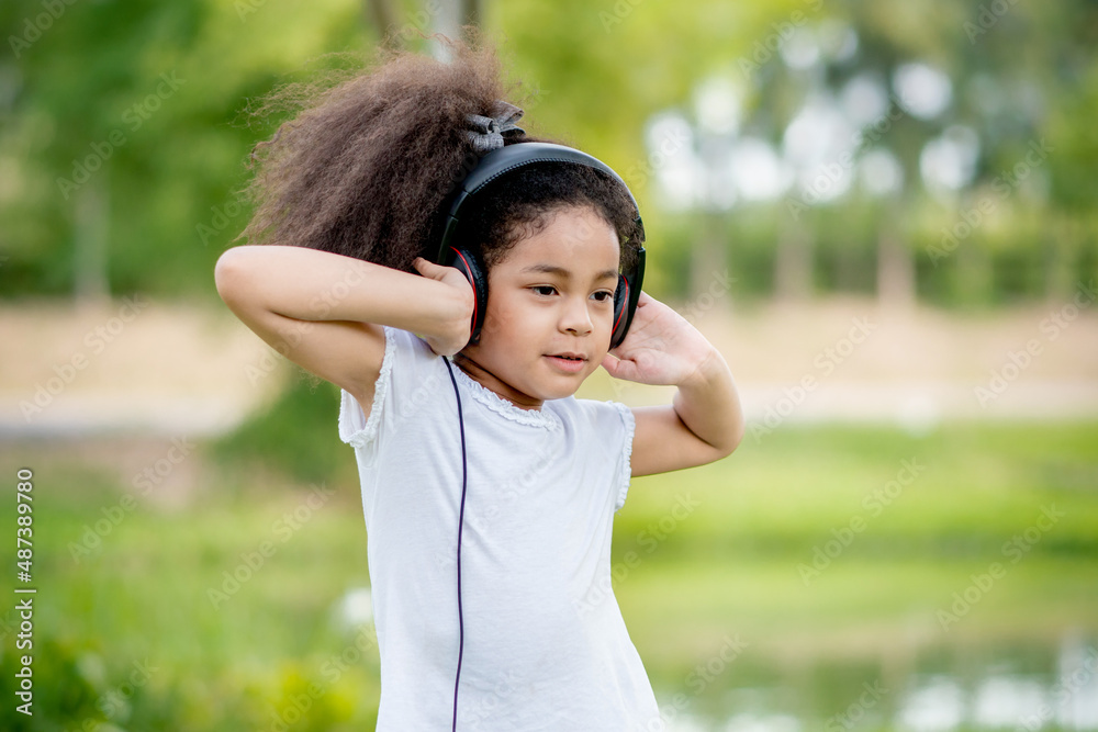 child girl listening music in headphones relax lifestyle in park outdoor nature background or wallpaper.