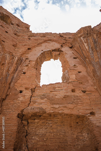 Vertical photograph of one of the cracked windows of the Belchite church bombed in the Spanish civil war on a sunny day with a blue sky with some clouds