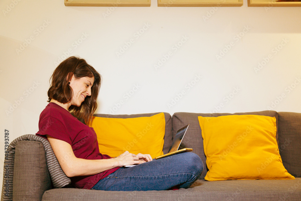 Obraz premium woman with laptop on the sofa with copy space