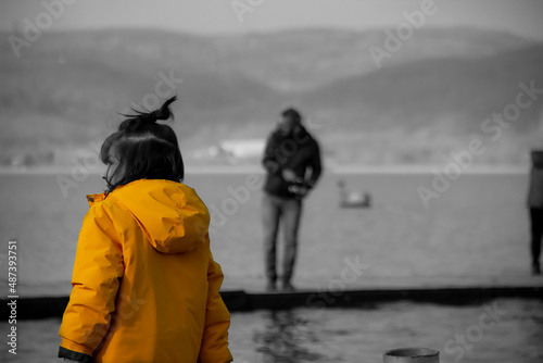 boy in yellow coat at lake
