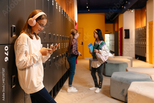 White blonde girl listening music after class at school