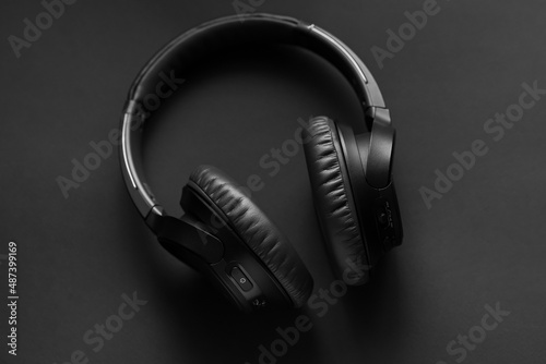 Black wireless headphones on a black background