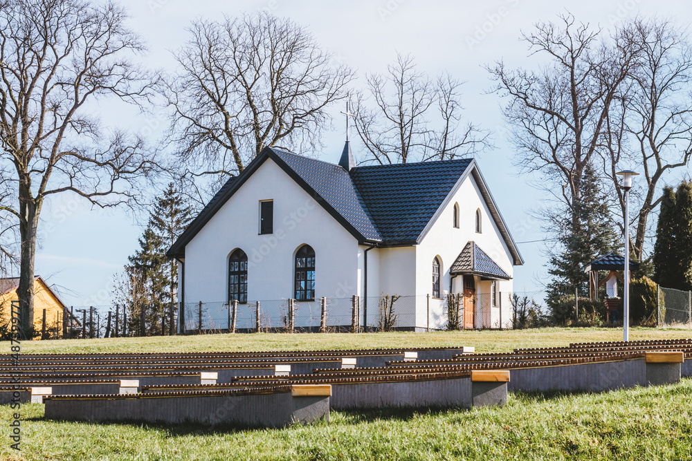 Piękny kościół w kształcie krzyża pośród parku.