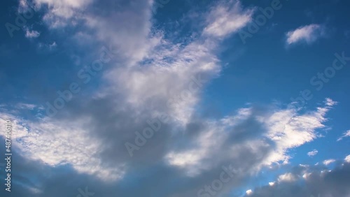 Fast moving clouds in the blue sky, at the end of winter, at sunrise. Flying passenger plane in the background. Accelerated motion.
