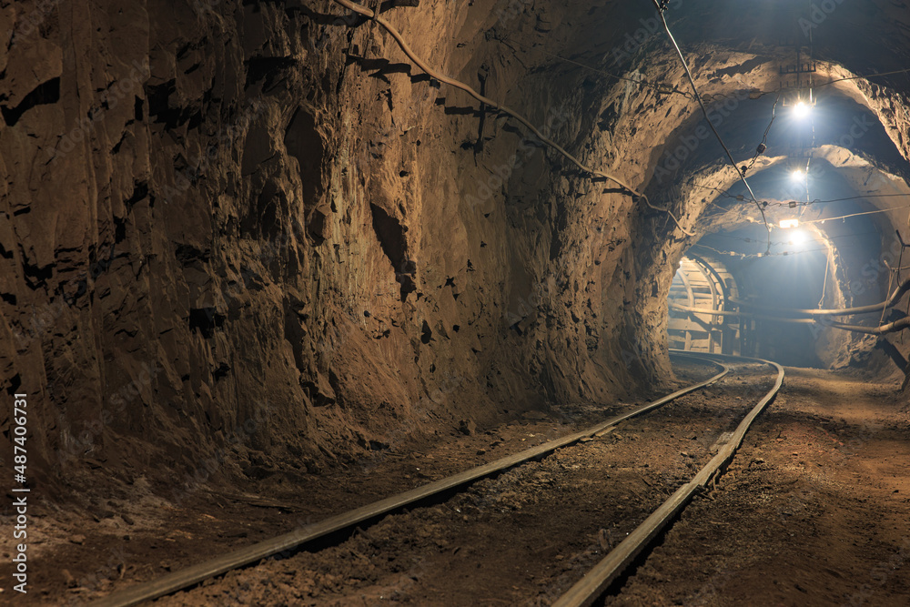 Narrow gauge railroad in the underground mine horizon. Technologies of mining of minerals by the underground method. Underground mine for mining ore Narrow gauge railroad in the underground mine horizon. Technologies of mining of minerals by the underground method. Underground mine for mining ore