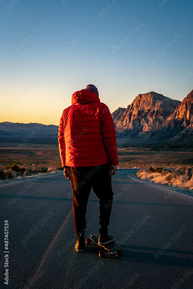 Skateboarder about to skate down an open road in Red Rock, Nevada