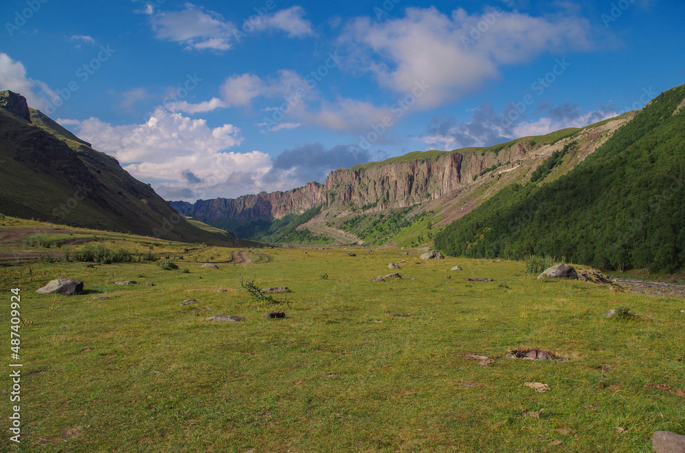 Beautiful evening view of meadow and mountain valley. View from camp on river Malka. Nature and travel. Russia, Caucasus, Kabardino-Balkaria