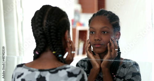 Canvas Print Teenager black girl looking at herself in mirror