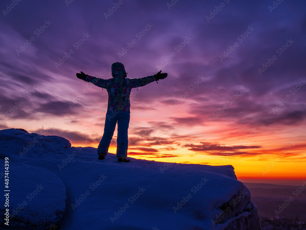 Obraz premium Silhouette of a man with hands raised in the beautiful sunset.