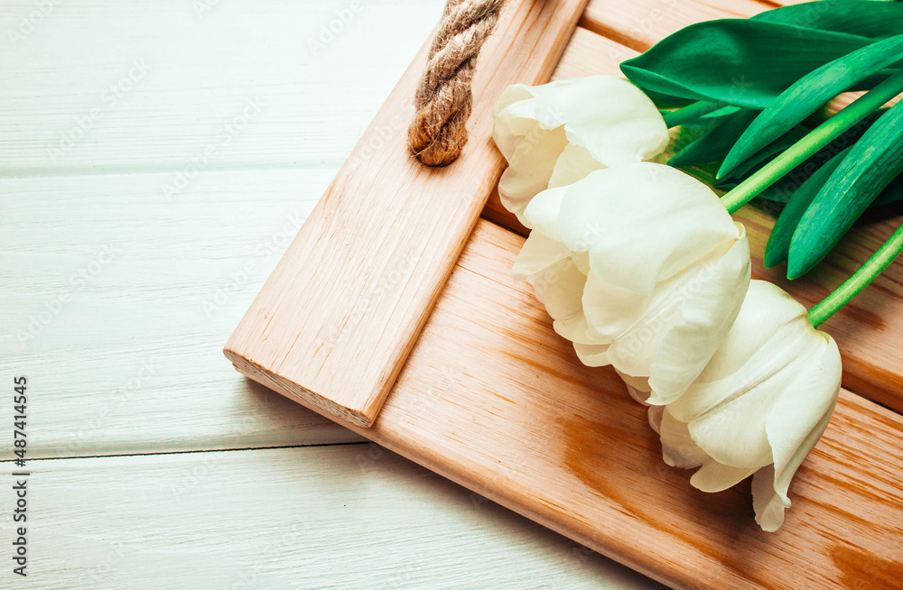 Tulips on wooden background and tray. In spring. Tulips on wooden background and tray. In spring.