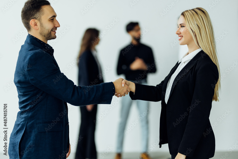 Business people shaking hands in front of collegues Business people shaking hands in front of collegues