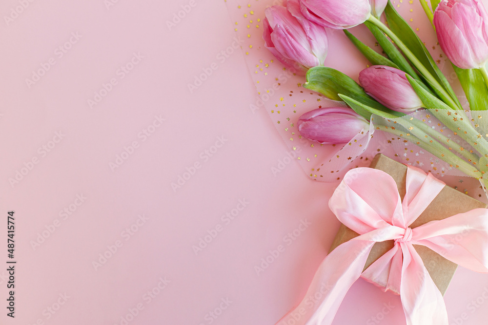 Pink tulips and gift box on pink background flat lay. Greeting card template with space for text. Happy womens day. 8 march. Happy Mothers day