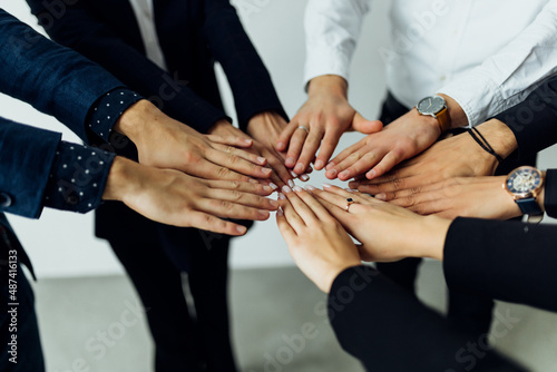People of different ages and nationalities fold their hands on each other, symbolizing their unity and support. Team of people who are set up for productive work and a positive result.