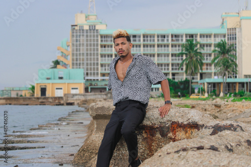 Portrait of cool young african man dancing at the beach on summer day photo