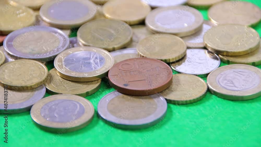 Coins on a green cloth rotate on a turntable, close-up, financial income or investment concept Coins on a green cloth rotate on a turntable, close-up, financial income or investment concept