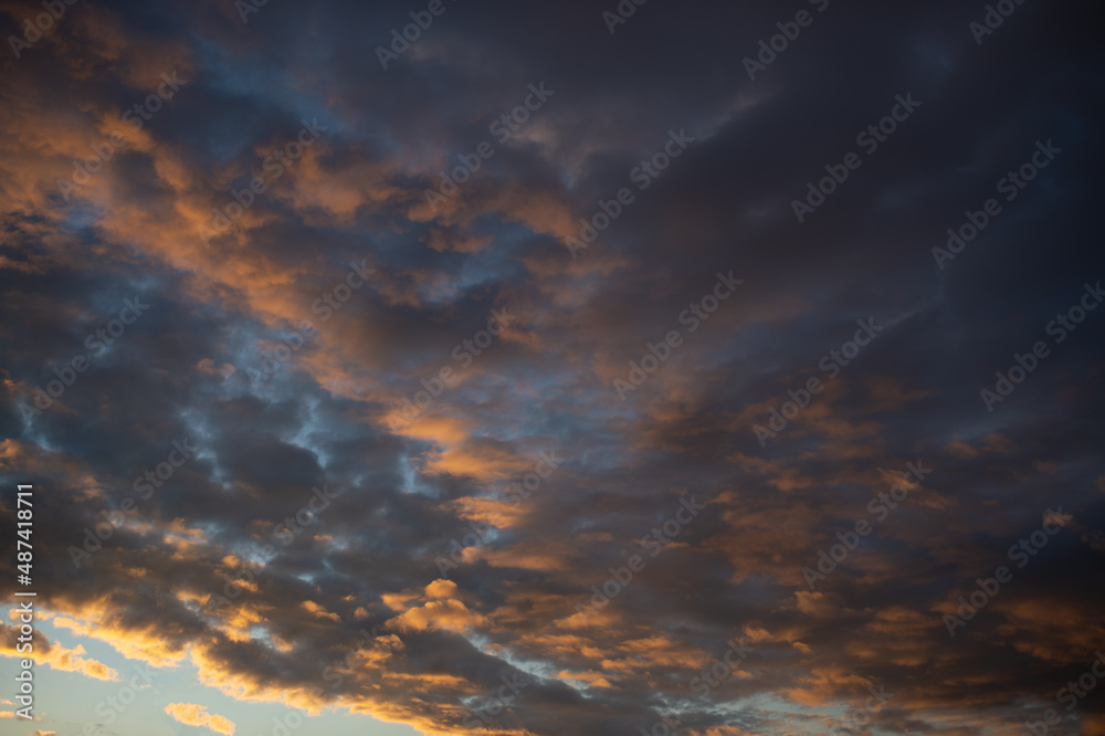 Fototapeta premium Dense dramatic painted clouds at sunset of the day against a blue sky